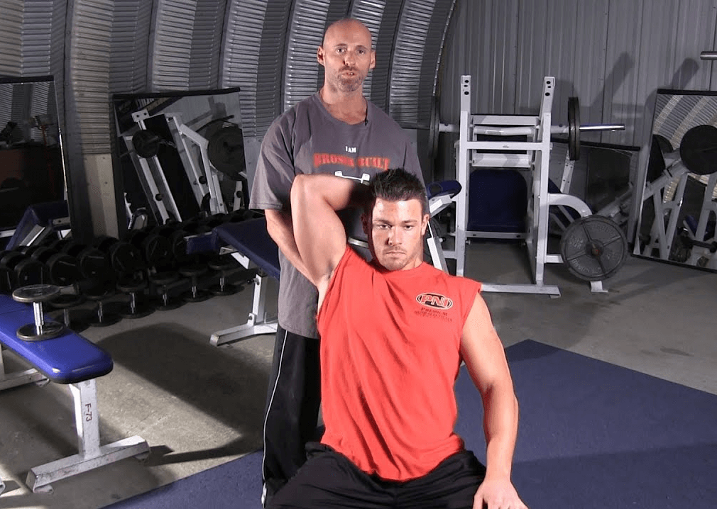 How is the one-arm overhead dumbbell extension done
