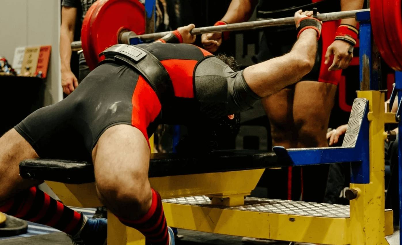 Wearing a weightlifting belt during bench presses can help improve your form, provide additional support for your core, and add stability to the movement